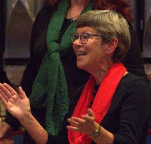 Tucson Women's Chorus singer A Tucson Women's Chorus singer laughing and clapping during a performance